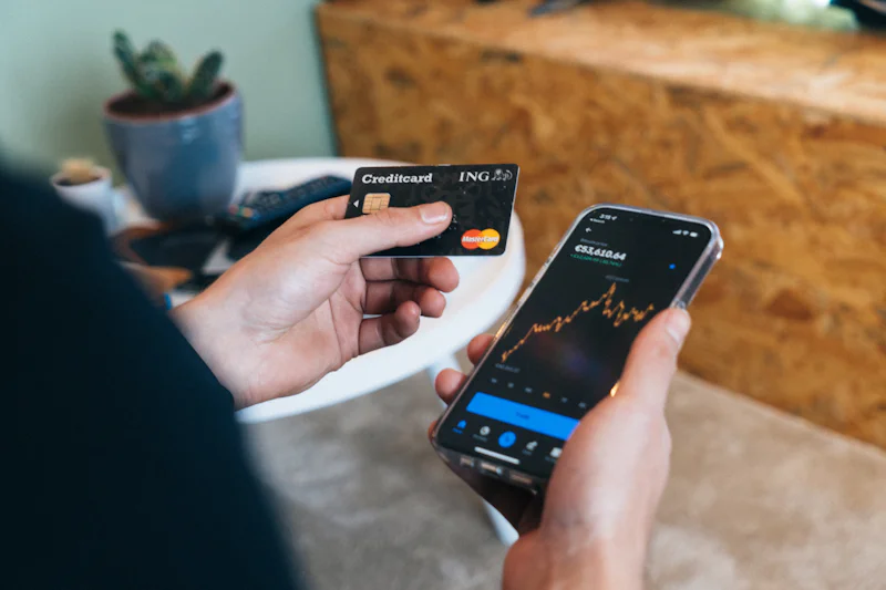 Person holding a smartphone and a bank card